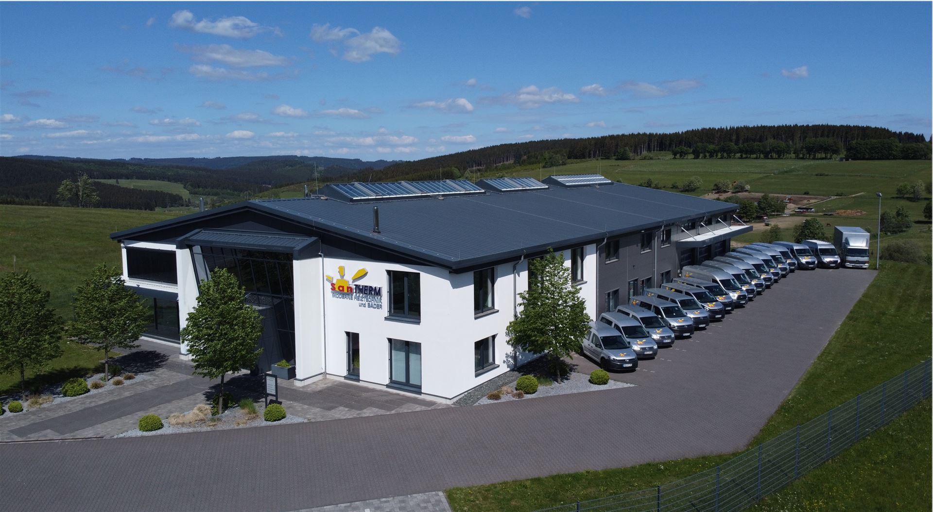 Zu sehen ist SanTHERM Gebäude mit Fuhrpark Fahrzeugen